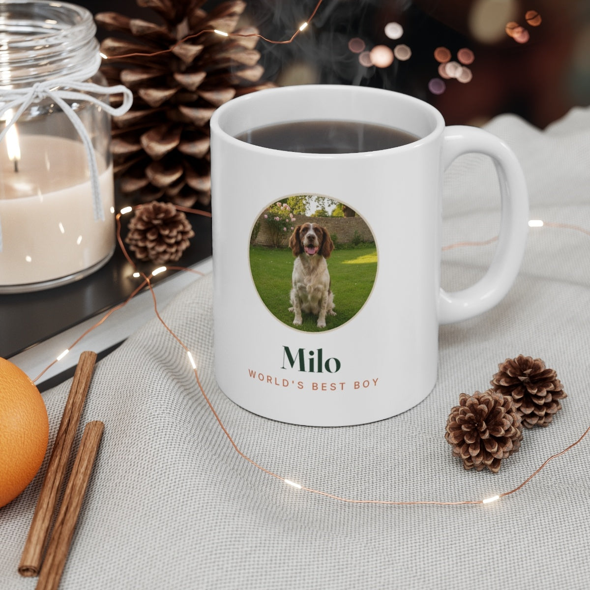 Pet photo mug mock-up filled with coffee on a table with pine cones, a candle and fairy lights