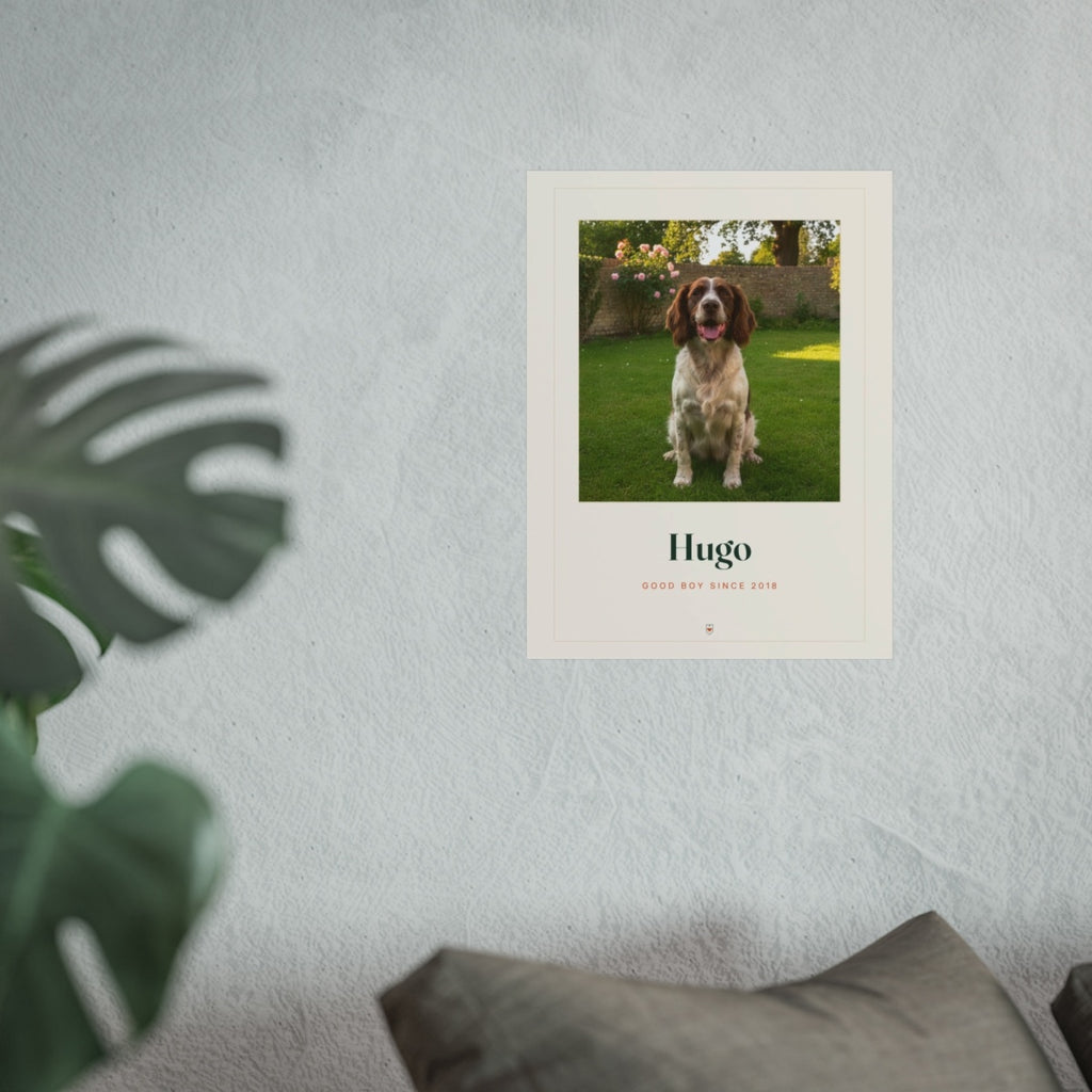 Pet photo print mock-up in the larger size on a grey wall above a sofa cushion, with a monstera leaf in front