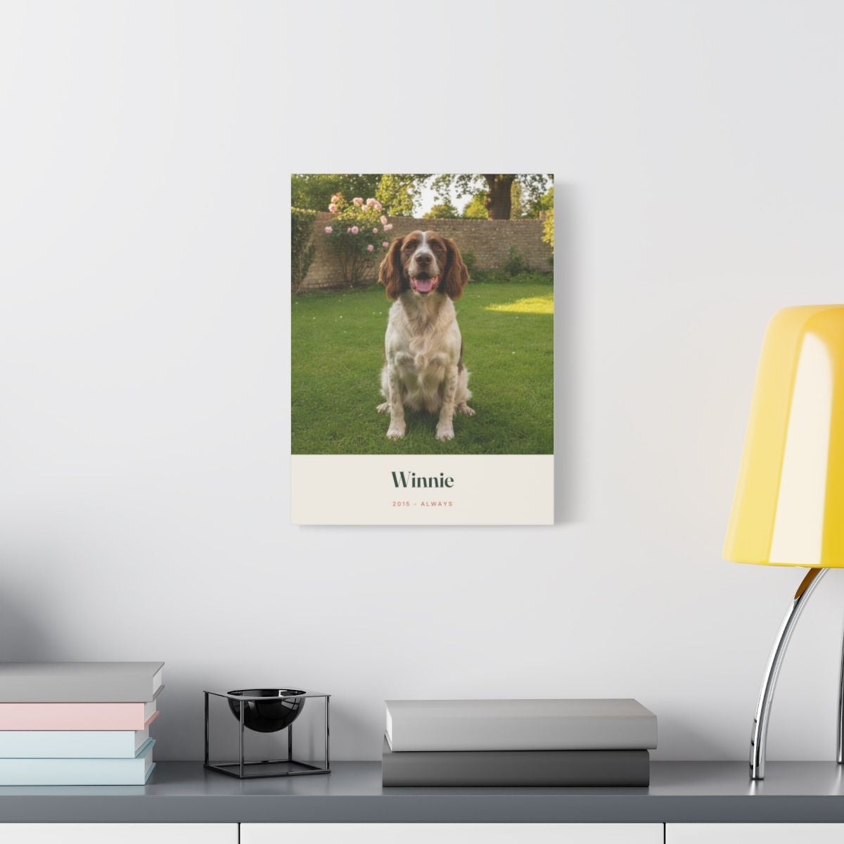 Pet photo stretched canvas mock-up on a white wall above a desk with books and a yellow lamp