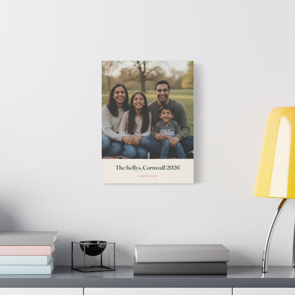 Personalised family photo canvas mock-up hung on a white wall above a desk with books and a yellow lamp