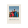 Personalised photo print with caption mock-up, two hikers on a fell above 'Lake District, summer 2026' in a printed cream border