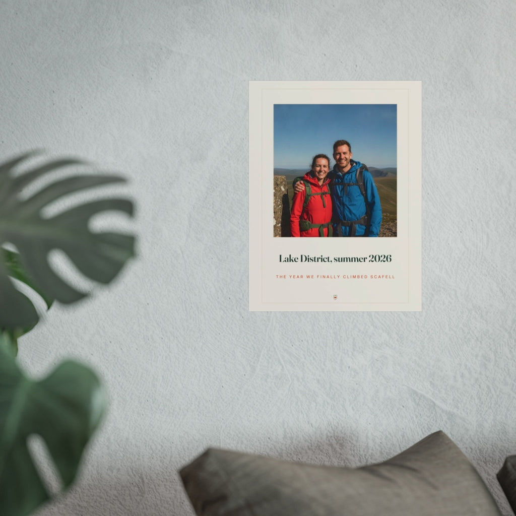 Photo print with caption mock-up in the larger size on a grey wall above a sofa cushion, with a monstera leaf in front