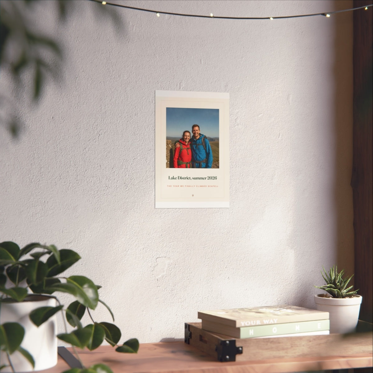 Photo print with caption mock-up in the smaller size on the sunlit white wall above the shelf, fairy lights overhead