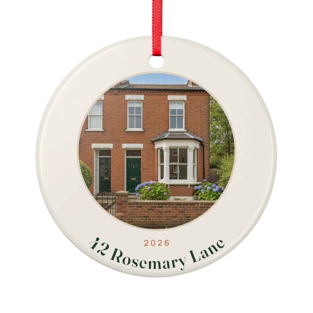 New home photo Christmas ornament mock-up, round ceramic with red ribbon, a brick house photo, '2026' and '42 Rosemary Lane'