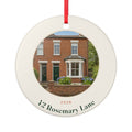 New home photo Christmas ornament mock-up, round ceramic with red ribbon, a brick house photo, '2026' and '42 Rosemary Lane'