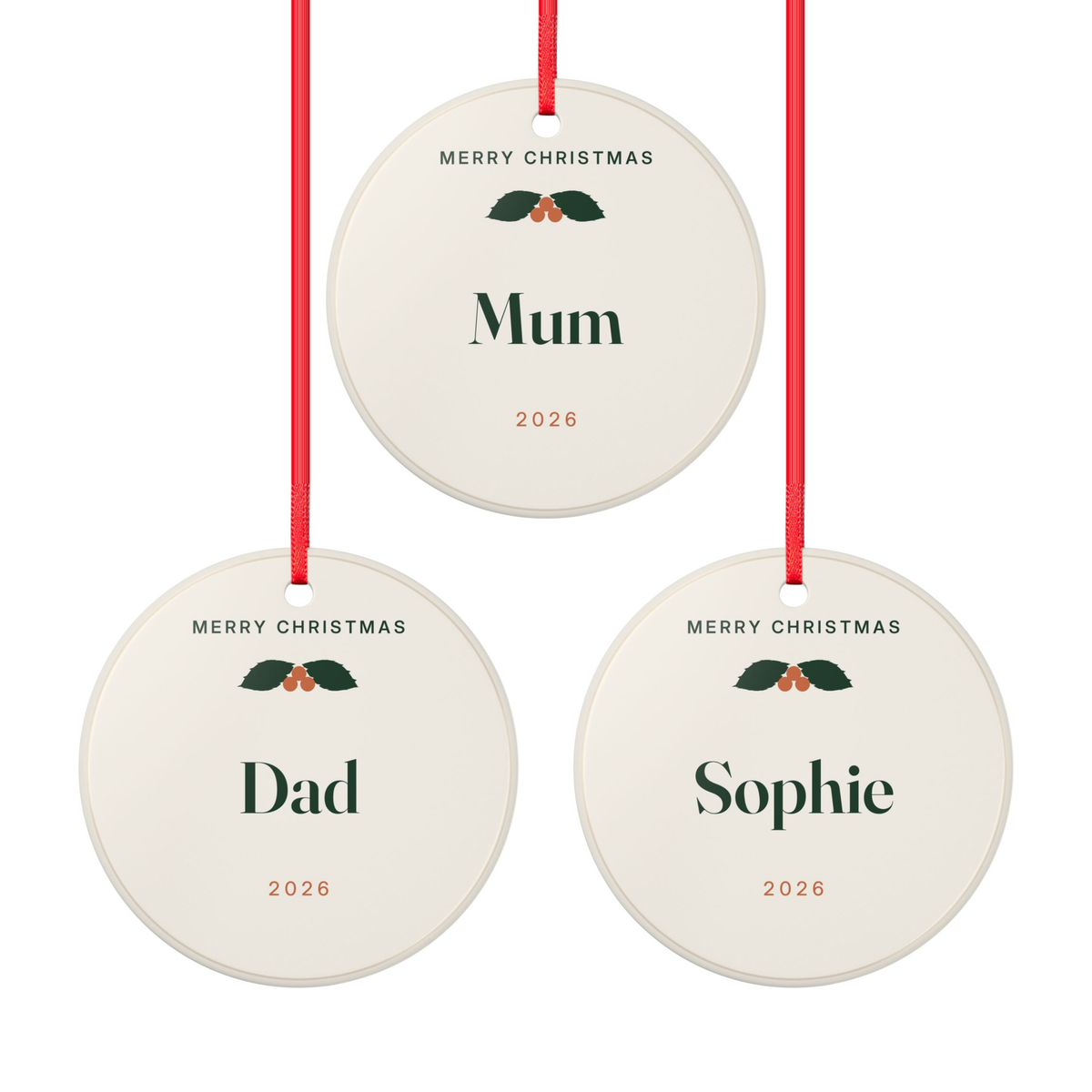 Family Christmas ornament set mock-up: three round ceramic ornaments with holly, reading 'Mum', 'Dad' and 'Sophie', '2026'