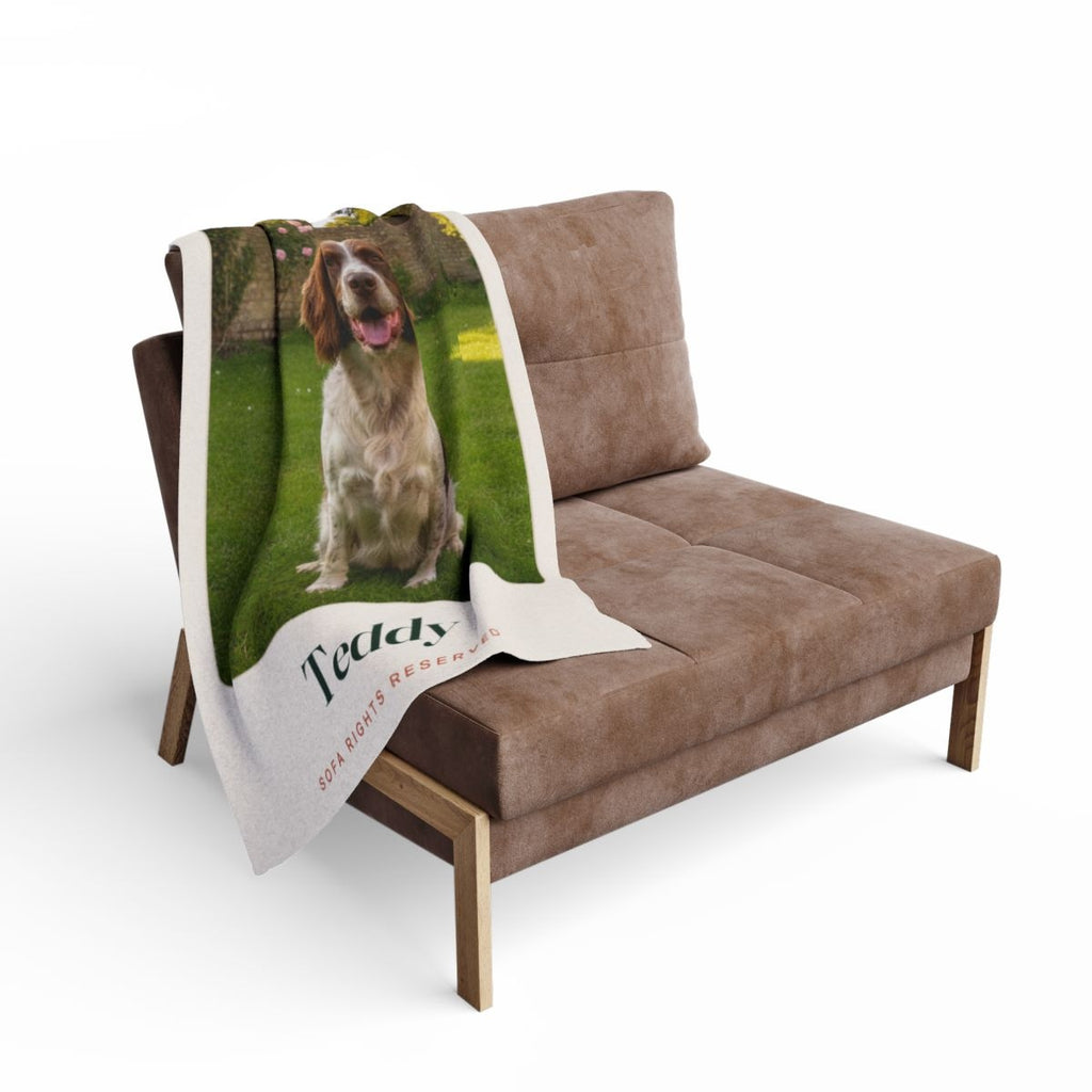 Dog photo fleece blanket mock-up draped over a brown armchair, the spaniel's photo and 'Teddy' visible
