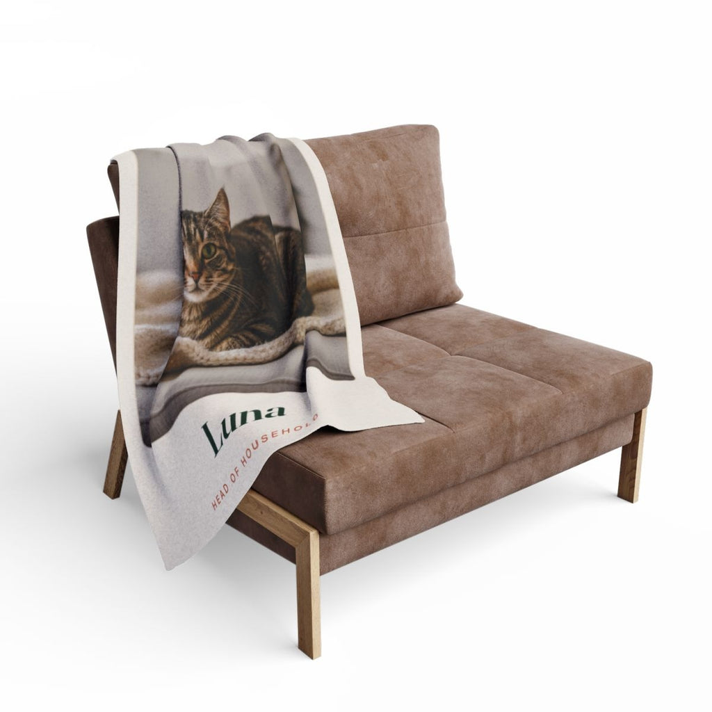 Cat photo fleece blanket mock-up draped over a brown armchair, the tabby cat's photo and 'Luna' visible