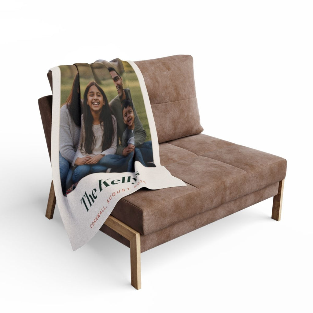 Family photo fleece blanket mock-up draped over a brown armchair, the family photo and 'The Kellys' visible