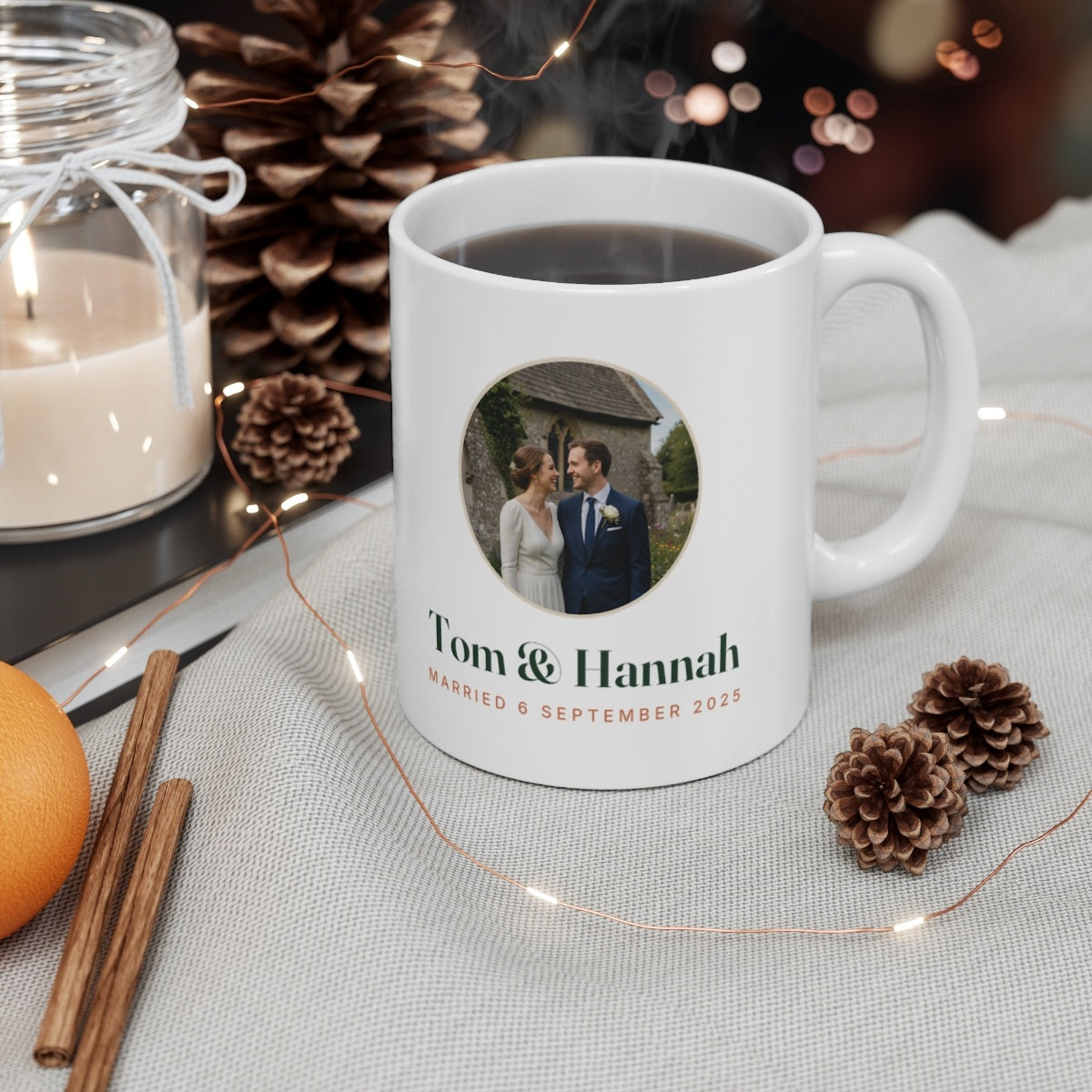 Personalised couple photo mug mock-up filled with coffee on a table with pine cones, a candle and fairy lights
