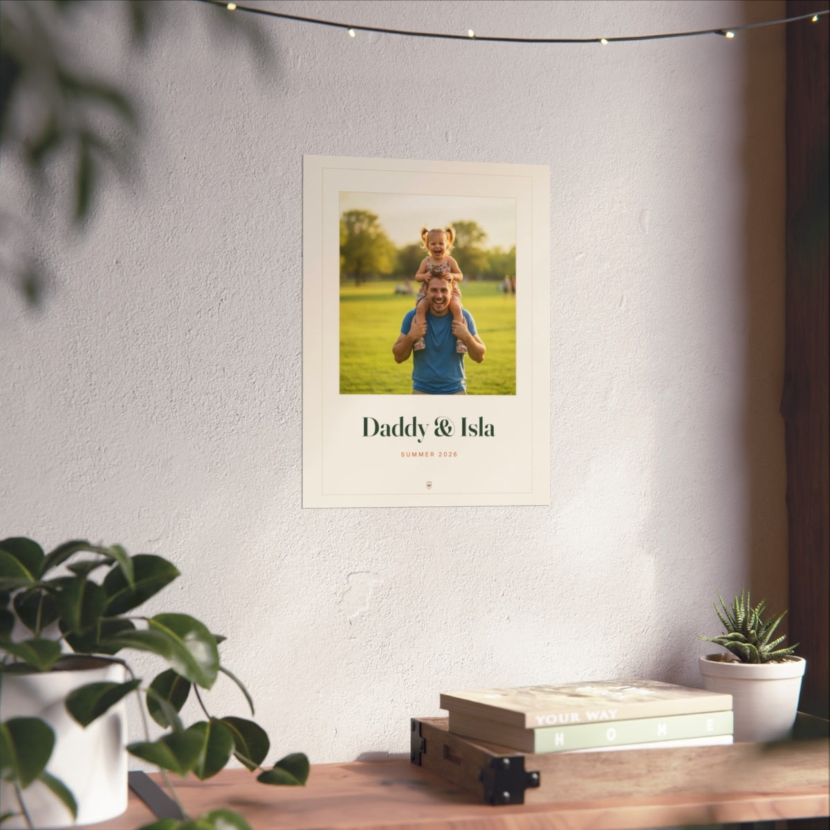 Personalised Dad photo print mock-up at 12 x 16 in on a white wall above a desk with books, plants and fairy lights
