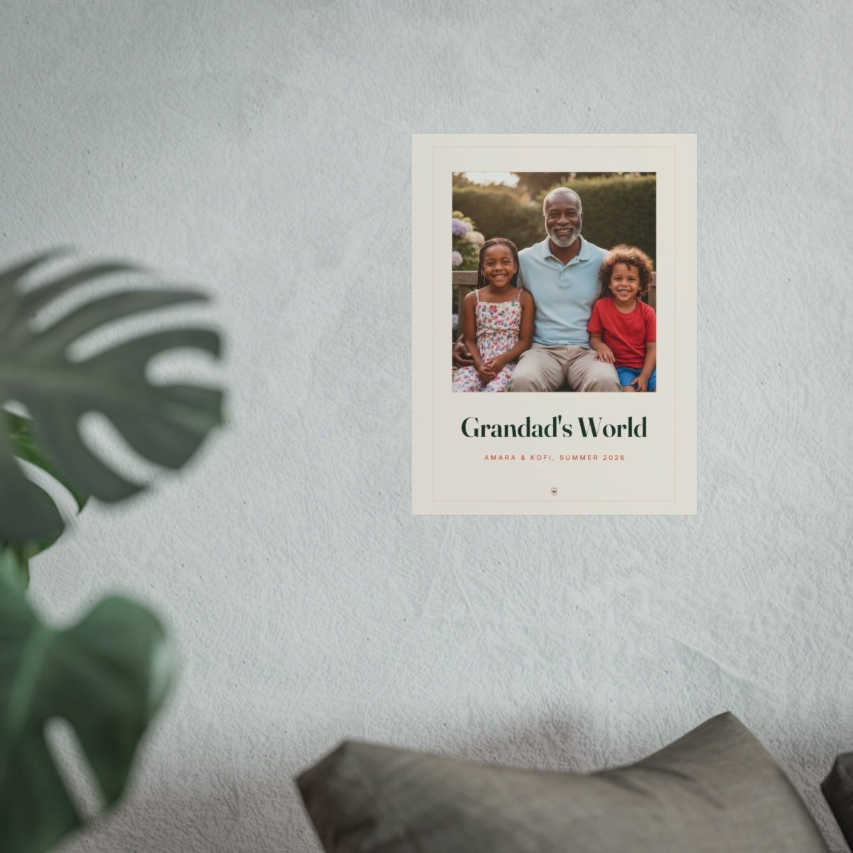 Grandparents photo print mock-up on a textured white wall above a grey sofa cushion with a monstera plant in front