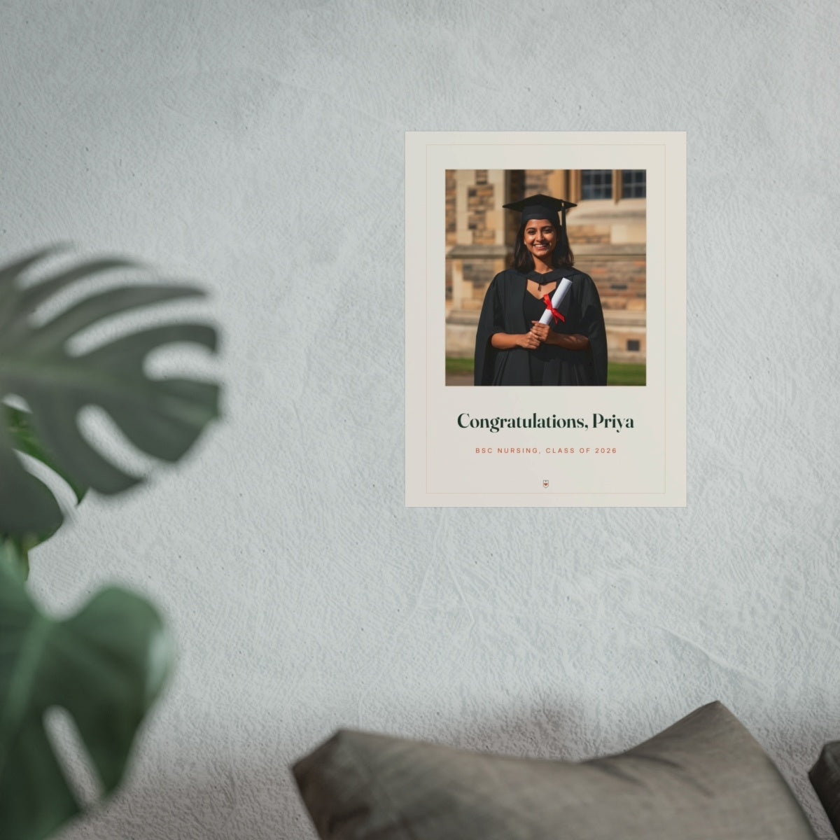 Personalised graduation photo print mock-up at the larger size on a pale wall above a sofa beside a monstera plant