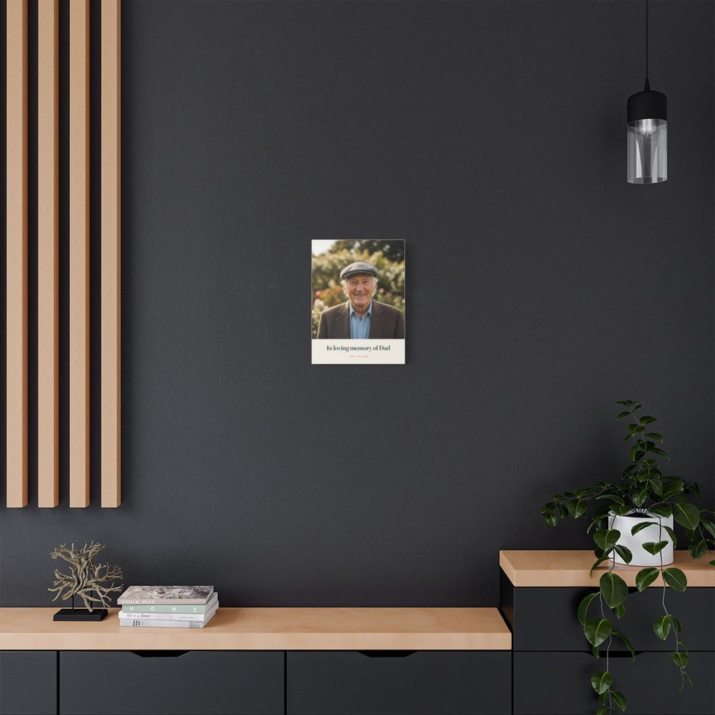 Personalised in loving memory photo canvas mock-up on a dark grey wall above a sideboard with books and a trailing plant