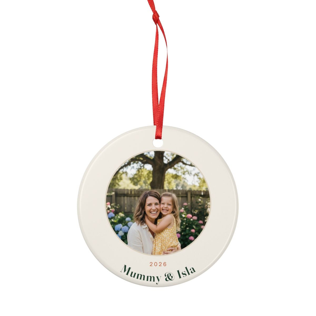 Personalised Mum photo Christmas ornament mock-up seen smaller with the red ribbon looped above, sample text 'Mummy & Isla'