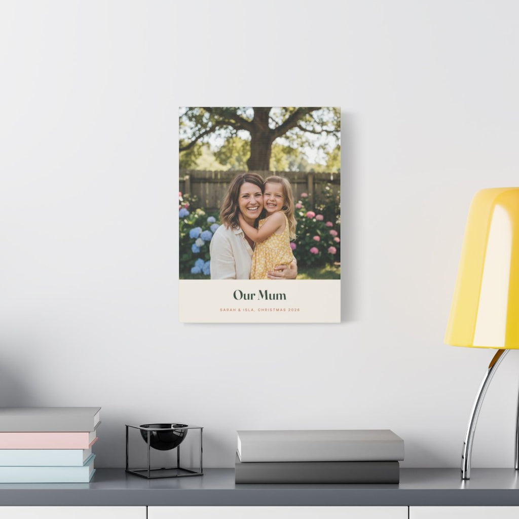 Personalised Mum photo canvas mock-up hung on a pale wall above a desk with books and a yellow lamp