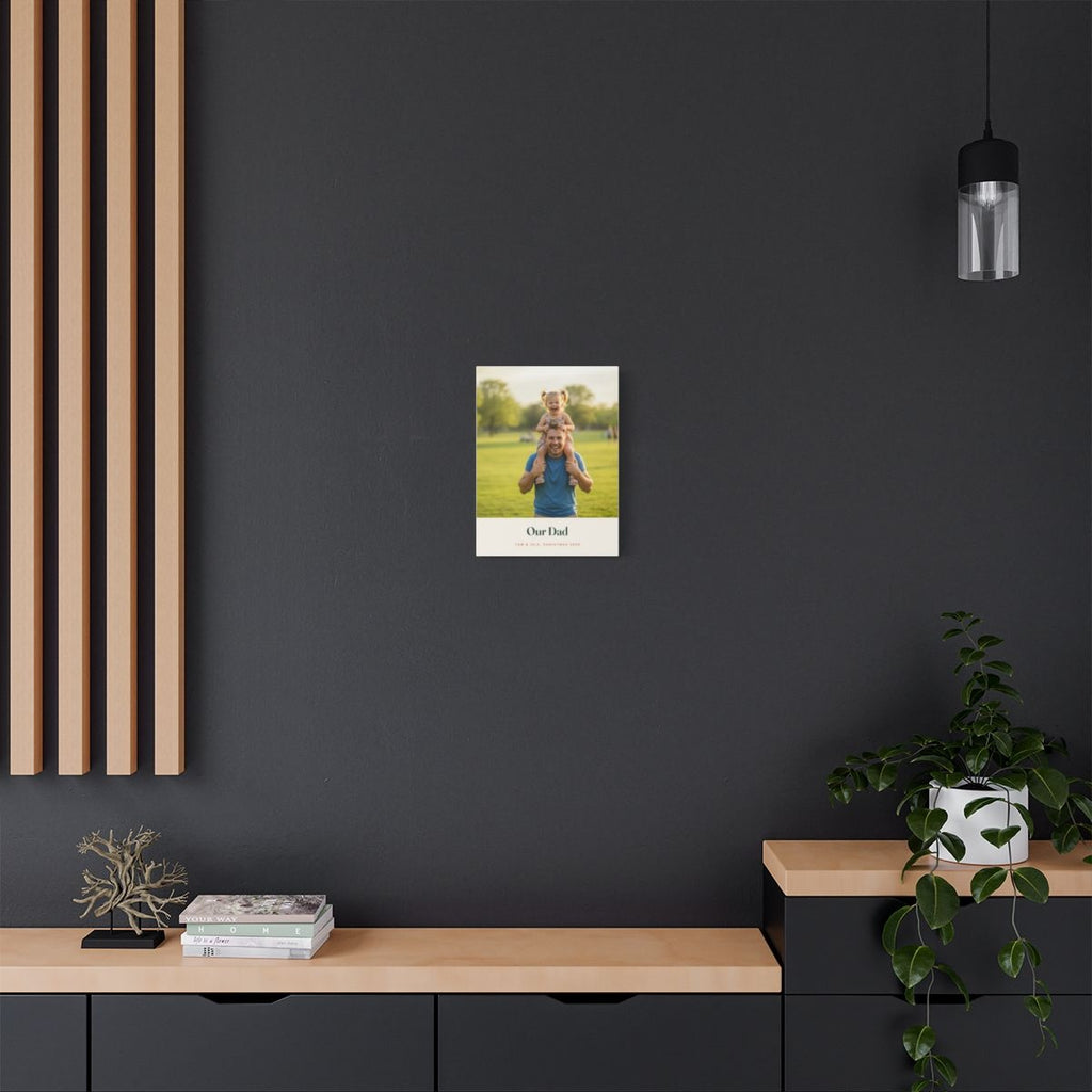 Personalised Dad photo canvas mock-up small on a dark grey wall above a wooden sideboard with plants and books