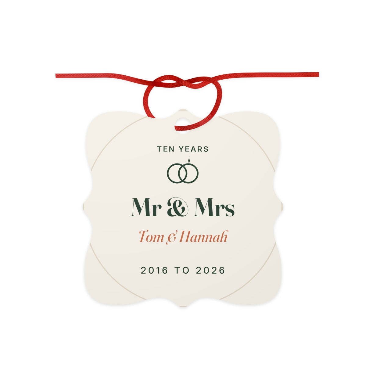 10th anniversary aluminium ornament mock-up with a red ribbon bow, 'Ten years', two rings, 'Mr & Mrs' and 'Tom & Hannah'