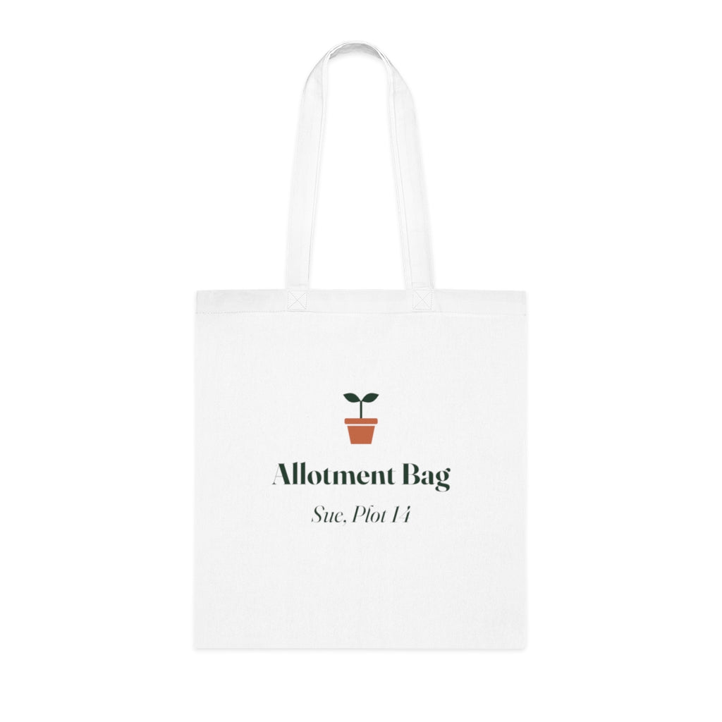 Personalised allotment tote bag mock-up, white cotton tote laid flat with a seedling, 'Allotment Bag' and 'Sue, Plot 14'