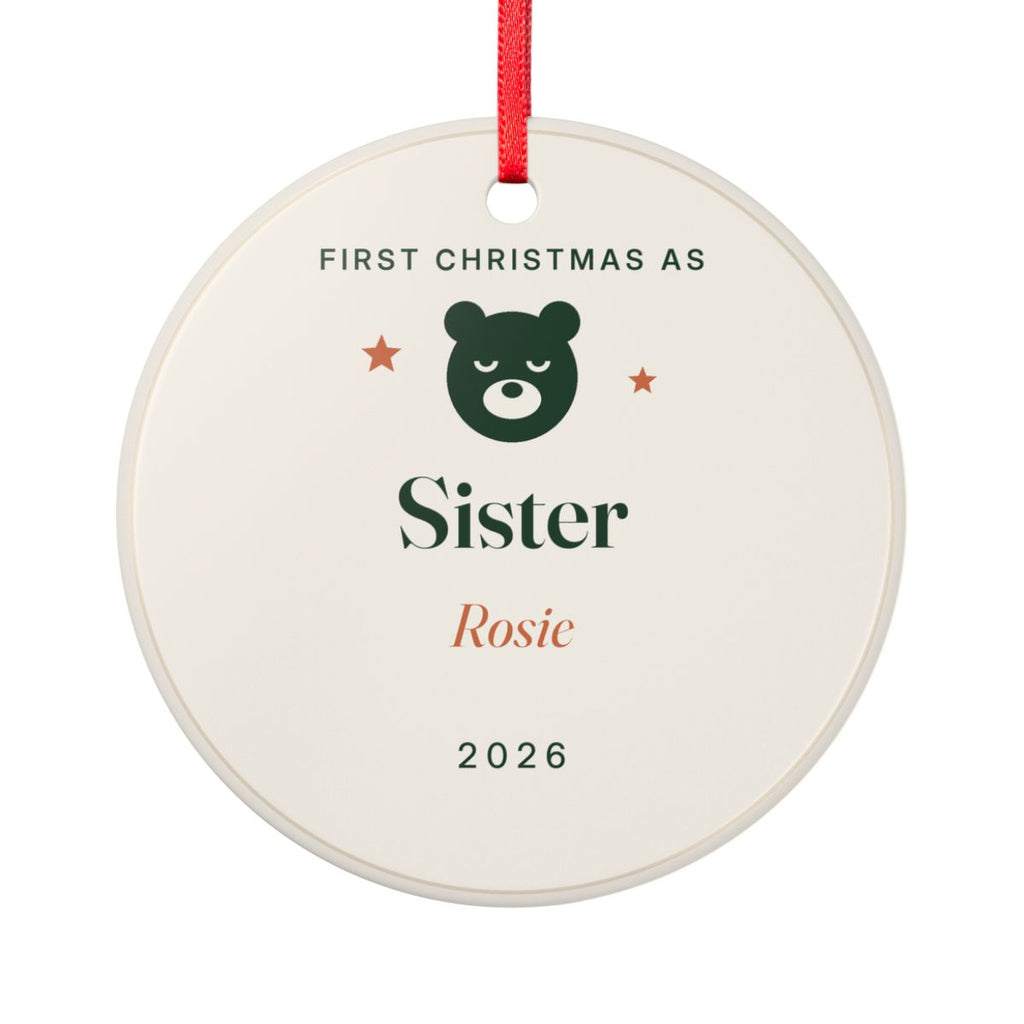 Personalised First Christmas as Sister ornament mock-up, round cream ceramic disc with a green bear, 'Sister', 'Rosie' and '2026'