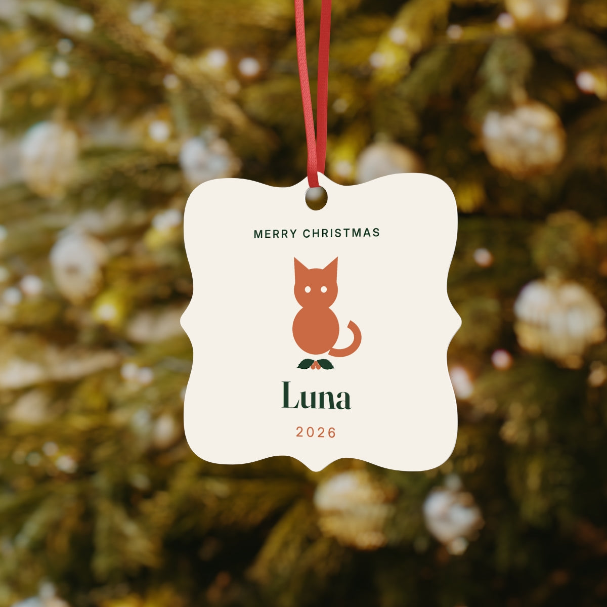 Cat Christmas aluminium ornament mock-up hanging by a red ribbon on a tree, printed 'Merry Christmas', 'Luna' and '2026'