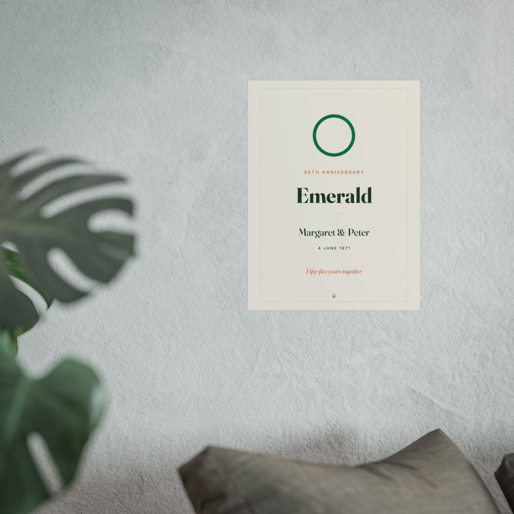 Emerald anniversary print mock-up hung on a pale wall beside a monstera plant and a grey sofa, larger size