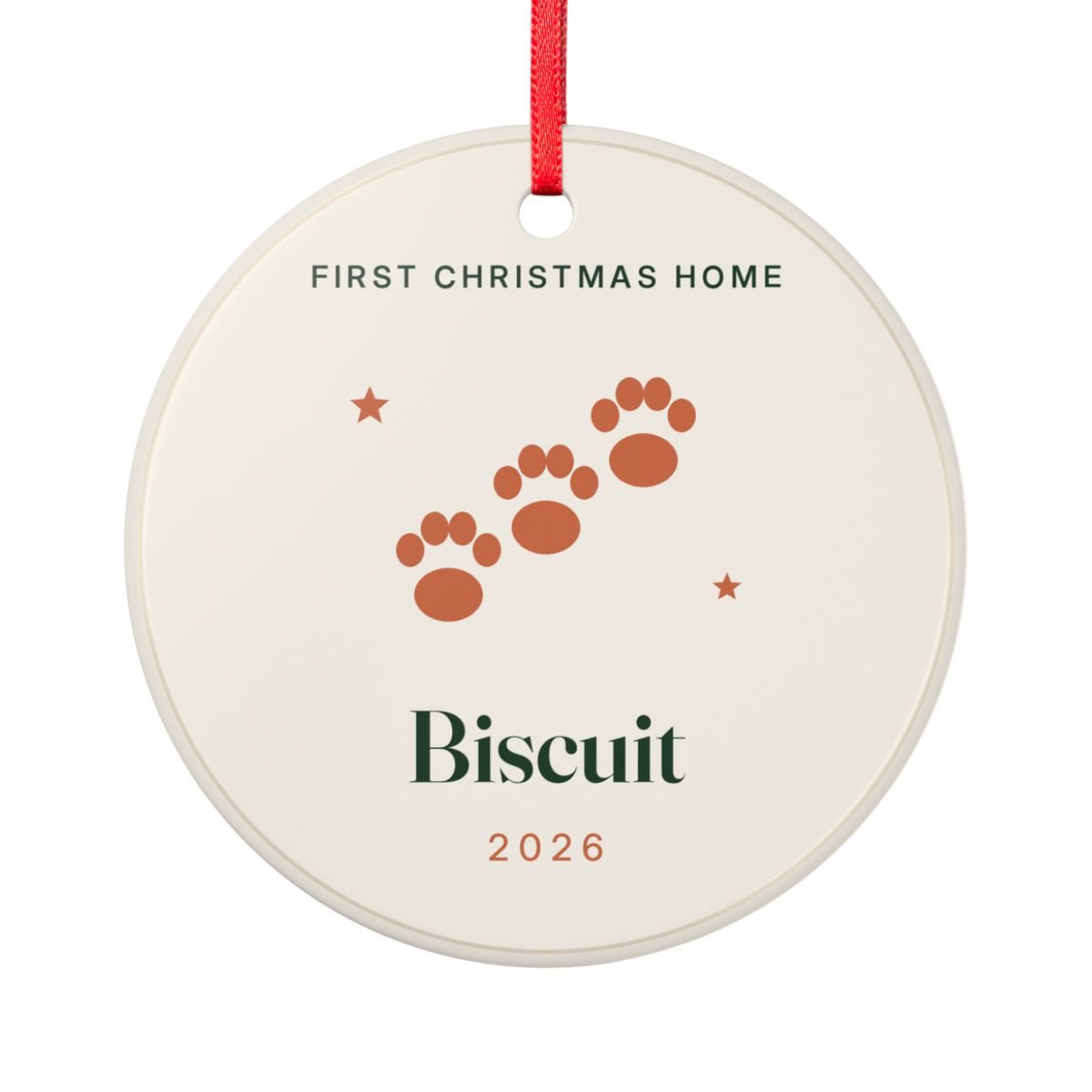 Personalised first Christmas home ornament mock-up for a rescue pet, three orange paw prints, 'Biscuit' and '2026'