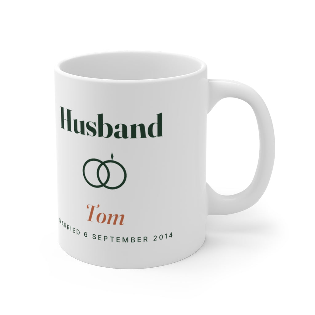 Personalised husband mug mock-up with the handle on the right, showing the rings motif and sample name 'Tom'