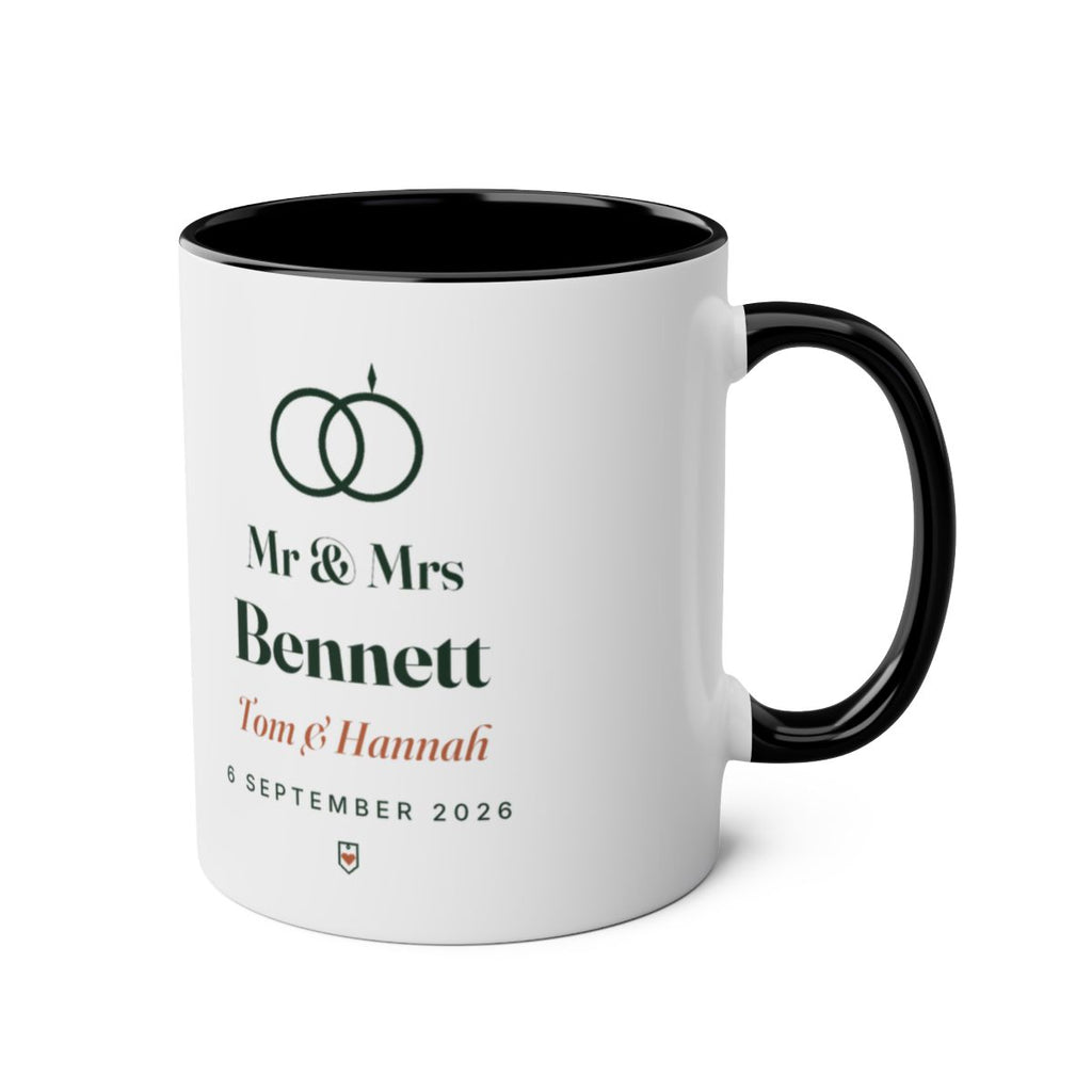Personalised Mr & Mrs mug mock-up, black two-tone, handle on the right, showing the rings motif and 'Mr & Mrs Bennett'