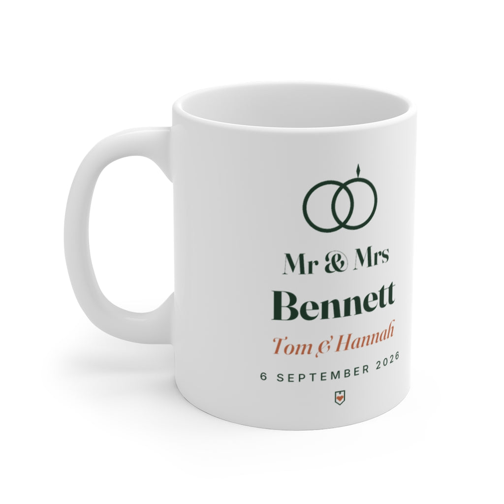 Personalised Mr & Mrs mug mock-up, handle left, printed with two rings, 'Bennett', 'Tom & Hannah' and '6 September 2026'