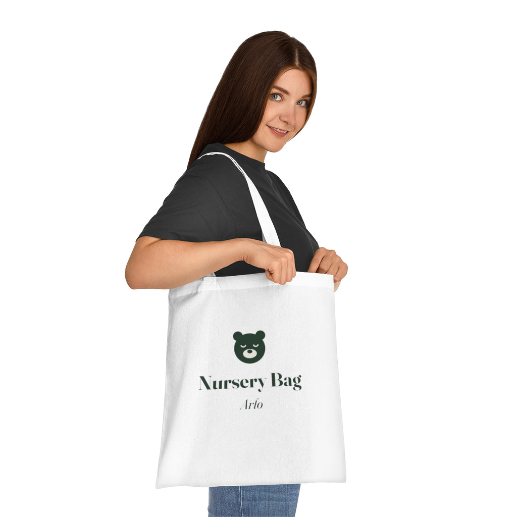 Nursery bag tote mock-up carried on a woman's shoulder for scale, 'Nursery Bag' and 'Arlo' printed in green