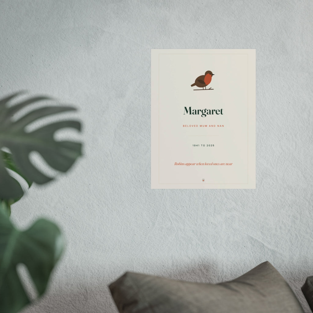 Robin memorial print mock-up for 'Margaret' on a pale wall above a sofa, monstera leaves in front, larger size