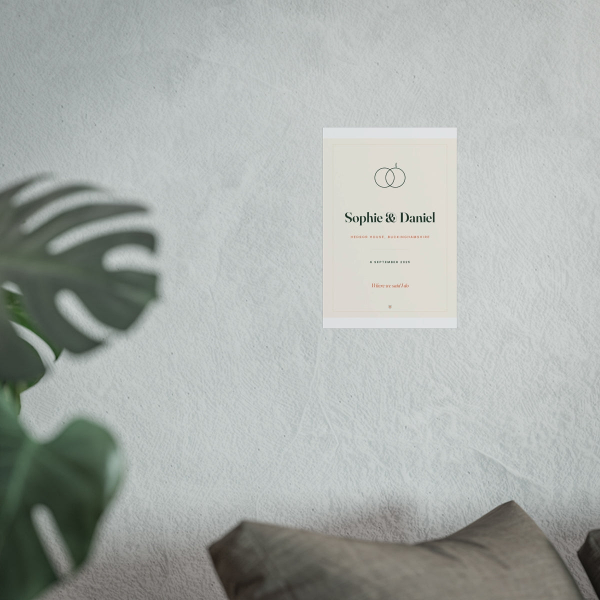 Personalised wedding print mock-up shown smaller on the pale wall above the grey sofa, monstera leaf in front